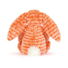 Load image into Gallery viewer, An orange plush bunny toy with a ribbed corduroy-like texture and a white fluffy tail, photographed against a clean white background.
