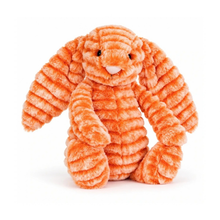 Load image into Gallery viewer, An orange and peach striped plush bunny toy with a textured, ribbed corduroy-like fabric, sitting on a white background.
