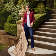 Load image into Gallery viewer, Woman standing on stone steps outdoors, holding a beige coat
