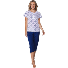 Load image into Gallery viewer, Woman wearing a white floral top and blue capri pants on a white background
