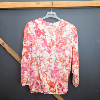 Floral patterned shirt on a hanger against a dark background