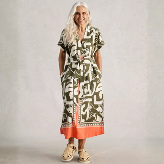 Woman wearing a patterned dress with a plain background