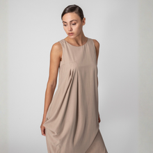 Load image into Gallery viewer, Woman wearing a beige sleeveless dress against a plain background
