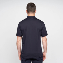 Load image into Gallery viewer, Man wearing a navy blue polo shirt on a light gray background
