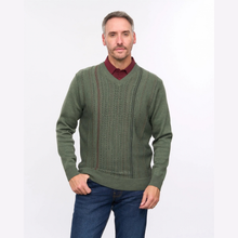 Load image into Gallery viewer, A man wearing a textured olive green v-neck sweater over a burgundy collared shirt and blue jeans, standing against a plain white studio background.
