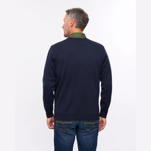 Load image into Gallery viewer, A man viewed from behind wearing a navy blue knit sweater with an olive green collar, paired with blue jeans, against a plain white studio background.

