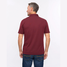Load image into Gallery viewer, A man viewed from the back wearing a short-sleeve polo shirt in maroon and blue jeans, standing against a plain white background.
