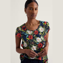 Load image into Gallery viewer, Woman wearing a colorful floral top against a plain background
