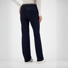Load image into Gallery viewer, A person shown from the back wearing dark navy blue straight-leg jeans, a white long-sleeve top, and white sneakers against a clean white studio background.
