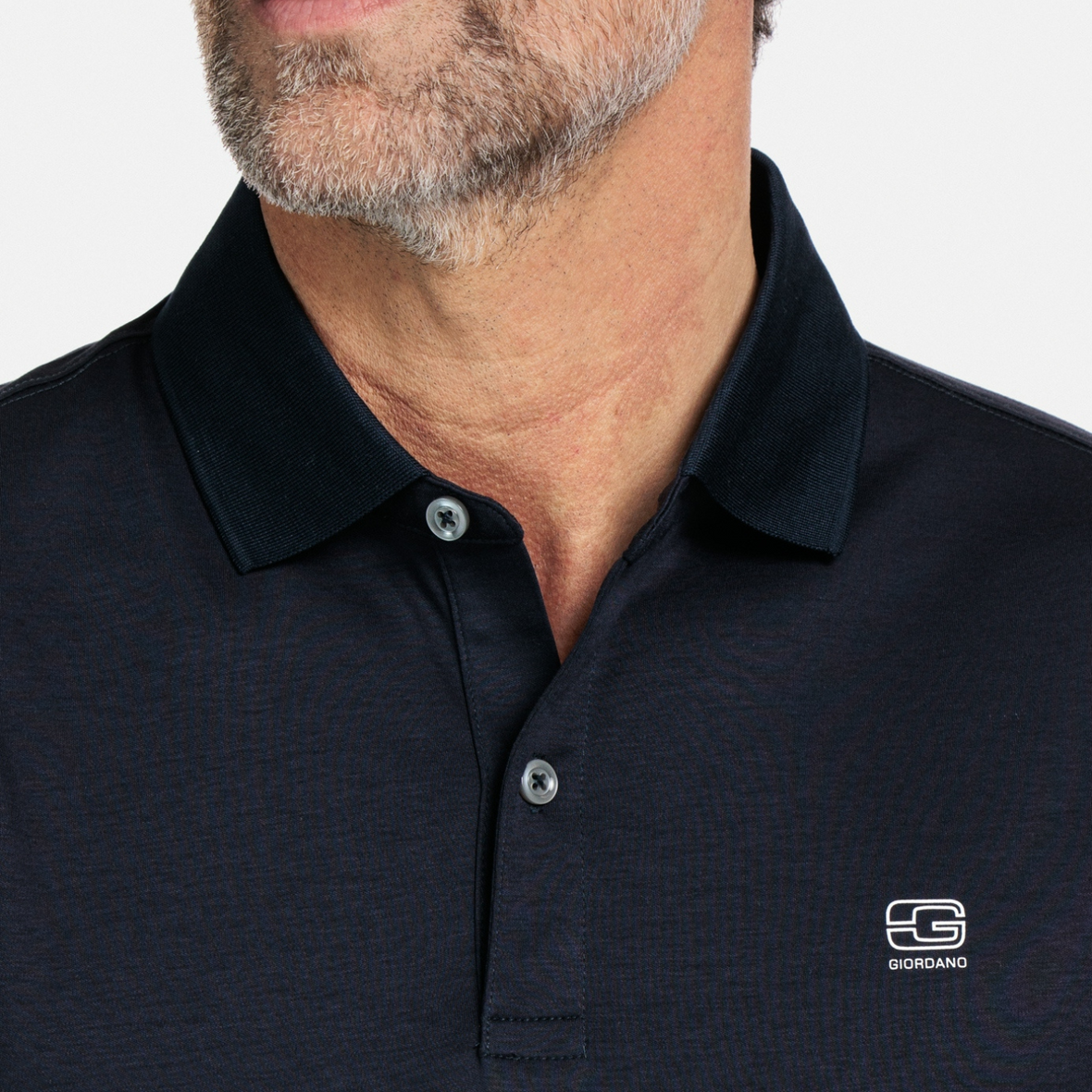 Up close image of polo shirt and button detail 