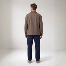 Load image into Gallery viewer, A man viewed from behind wearing a brown long-sleeve overshirt, dark blue jeans, and gray sneakers, standing against a neutral light gray studio background.
