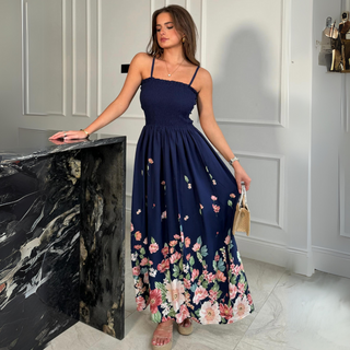 female model wearing girl in mind maxi dress in navy print with hand on table 