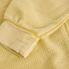 Load image into Gallery viewer, Close-up of a textured yellow fabric with a folded corner.
