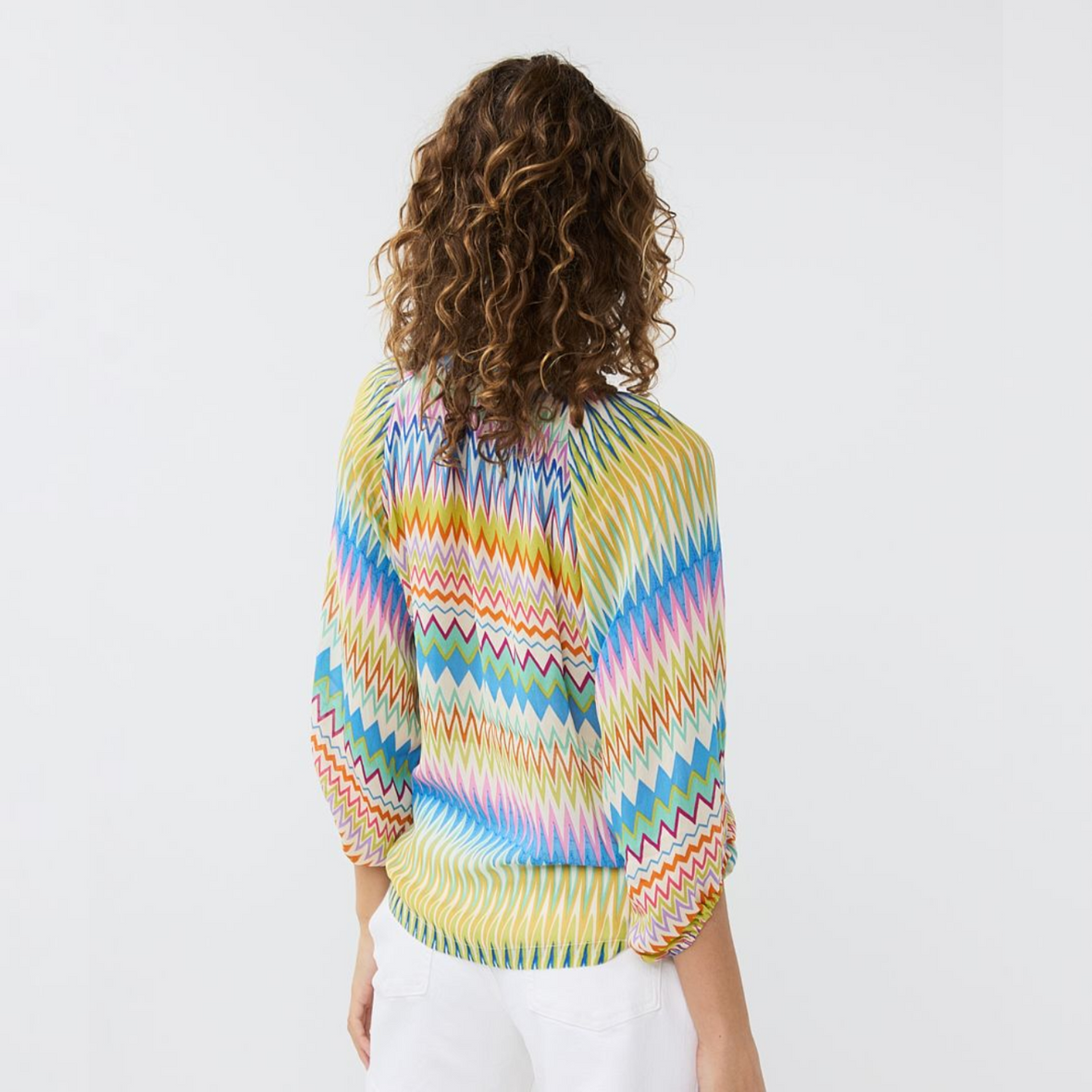 female model wearing esqualo raglan blouse in multicolour print with hands down by side