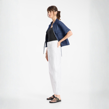 Load image into Gallery viewer, Woman wearing a navy jacket, black top, white pants, and sandals on a white background
