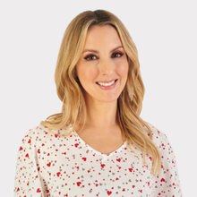 Load image into Gallery viewer, Close-up of model in heart print jersey nightdress, highlighting fabric texture, playful heart pattern, and soft, cozy material.
