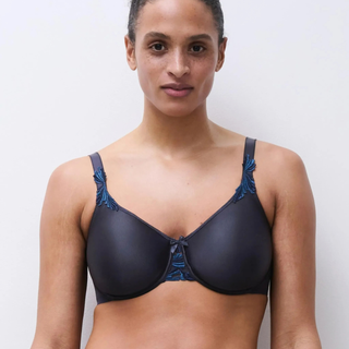 Woman wearing a Navy bra with blue trim against a plain background