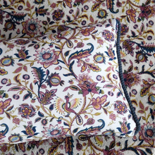 Load image into Gallery viewer, Detail of the cushion on the fabric used. White background with plum floral details. 
