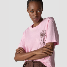 Load image into Gallery viewer, Person wearing a pink t-shirt with a palm tree design on a plain background
