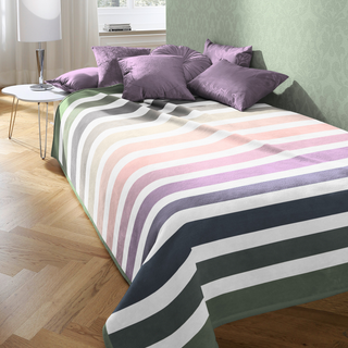 Throw over bed with purple cushions 