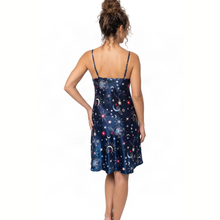 Load image into Gallery viewer, A woman shown from the back wearing a navy blue satin slip dress with a celestial print of stars, moons, and planets, set against a plain white background.
