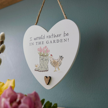 Load image into Gallery viewer, Heart-shaped sign with garden-themed illustration and text &#39;I would rather be in the garden!&#39; on a teal wall.
