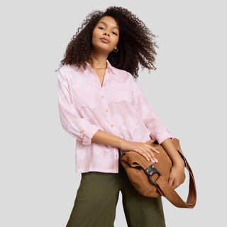 Close half view of Model posing wearing White Stuff Sophie Pink Jacquard Shirt in pink, with a light grey background.