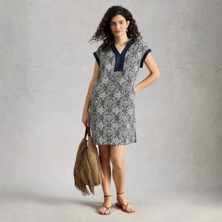 Woman wearing a patterned dress with a plain background