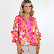 Load image into Gallery viewer, Female model smiling wearing pink and orange floral top
