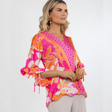 Load image into Gallery viewer, Female model wearing pink and orange floral top looking to the right 
