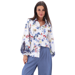 Woman wearing a floral blouse and blue pants on a white background
