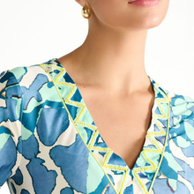 Load image into Gallery viewer, Close-up of a woman wearing a blue and green patterned dress with a blurred background
