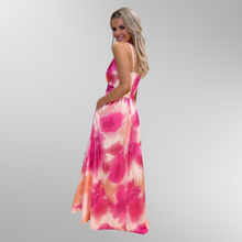 Load image into Gallery viewer, Model standing and smiling wearing Kate and Pippa maxi dress Lola in pink. One hand is in the side pocket.
