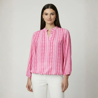 Woman in Pink Blouse with white trouser on pale background 