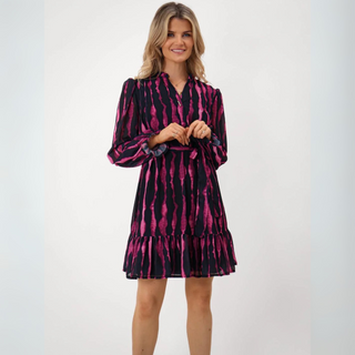 Woman wearing a navy and pink patterned dress on a white background