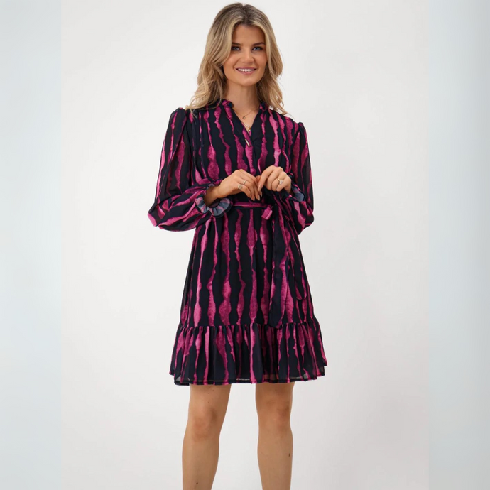 Woman wearing a navy and pink patterned dress on a white background