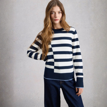 Load image into Gallery viewer, Woman wearing a navy and white striped sweater against a gray background
