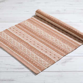 Roll of striped rug on a light wooden floor