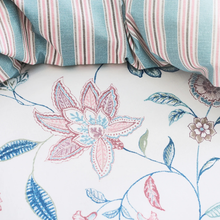 Load image into Gallery viewer, Close-up of floral embroidery on fabric with striped fabric in the background
