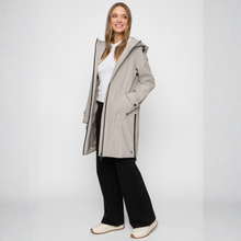 Load image into Gallery viewer, Woman wearing a long beige coat on a white background
