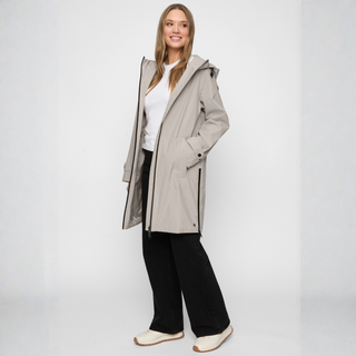 Woman wearing a long beige coat on a white background
