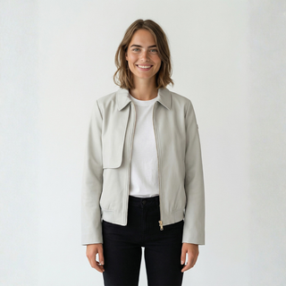 Woman wearing a light cream jacket over a white shirt on a plain background