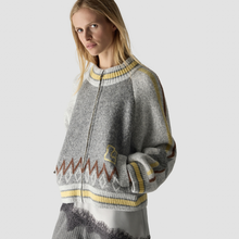 Load image into Gallery viewer, A woman wearing a gray knit zip-up sweater with yellow and brown patterned accents, photographed against a light gray studio background.
