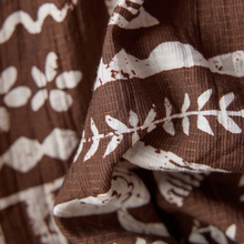Load image into Gallery viewer, Close-up of brown fabric with white floral patterns
