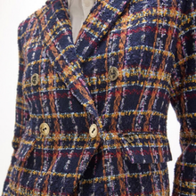 Load image into Gallery viewer, A close-up of a double-breasted tweed blazer with a navy blue base and a multicolor plaid pattern of orange, yellow, red, and white, featuring gold buttons.
