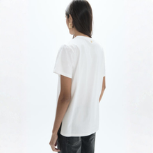 Load image into Gallery viewer, A woman shown from the back wearing a white short-sleeve t-shirt and dark gray jeans, photographed against a clean white studio background.
