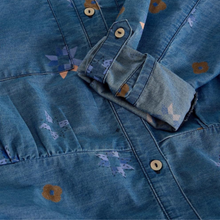 Load image into Gallery viewer, Close-up of a blue denim jacket with floral patterns and wooden buttons.
