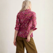 Load image into Gallery viewer, A woman shown from the back wearing a pink floral long-sleeve blouse and olive green pants against a plain off-white background.
