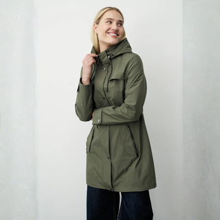 Woman wearing a green parka against a plain background