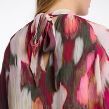 Load image into Gallery viewer, Close-up of a colorful floral blouse with a blurred background
